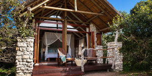 Stone and glass walls open onto private decks with gorgeous mountain views.  Each room has beautiful soft netting surrounding a king bed, a sitting area, writing desk, fireplace and ceiling fan. The bathrooms are fitted with a large romantic tub, copper sink and a private outdoor shower for an â€œAfrican bushâ€ experience.