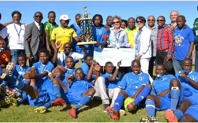 Kameraadskap en Sport wen weer eens by die onlangse Overstrand Burgemeesterssportfees op die Zwelihle Sportgronde. In die middel staan die Mighty Blues Mens Sokkerspan se trotse kaptein, â€œBuddyâ€ met die gesogte trofee wat deur hulle gewen is. Links van hom is Masizole Mnqasele (MPP) en regs is Overstrand se Uitvoerende Burgemeester, Raadsdame Nicolette Botha-Guthrie.