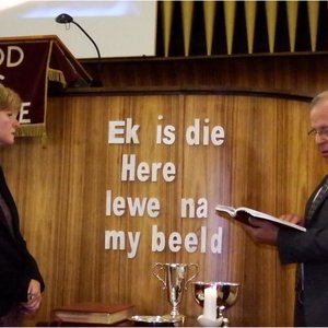 Regs is ds Dirk van Dyk besig met die bevestiging van dr Lisel Joubert as NG-leraar