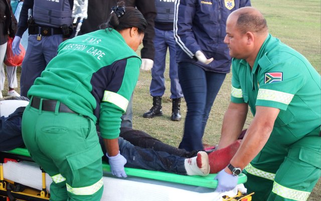 Die "parmantige", bebloede Christo Newman word hier in die ambulans gelaai.