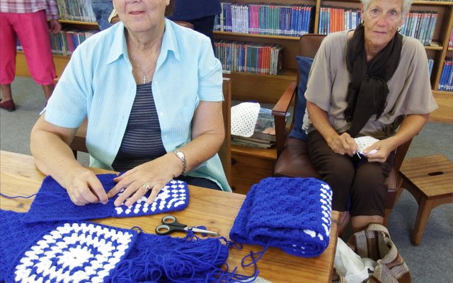 Twee flink dames wat begin het om kombersblokkies in Gansbaai Biblioteek aanmekaar te werk, is Linda Woods (links) en Chrissie Pretorius.