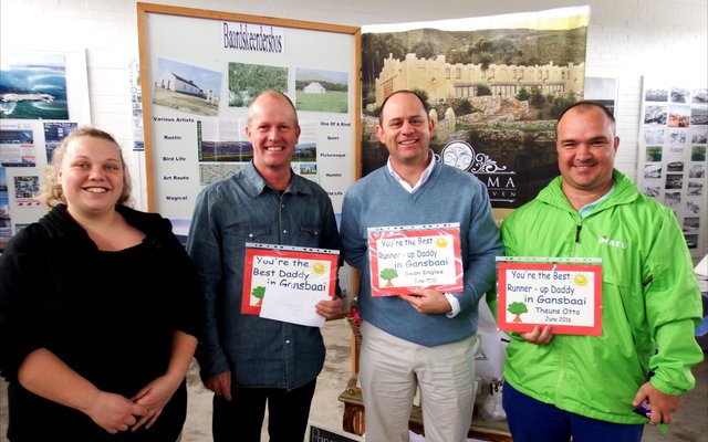 Gansbaai Toerisme se â€œBest Gansbaai Dadâ€ kompetisie het vele pret met kinder-sÃªgoed oor hul vaders opgelewer. Die drie wen-paâ€™s was gelukkig genoeg om sertifikate en sjokolade te ontvang. Vlnr is Doulene Els (Gansbaai Toerisme) en Hein van Wyk (wenner) saam met die twee â€œrunner-upsâ€, Sean Ingles en Theuns Otto.