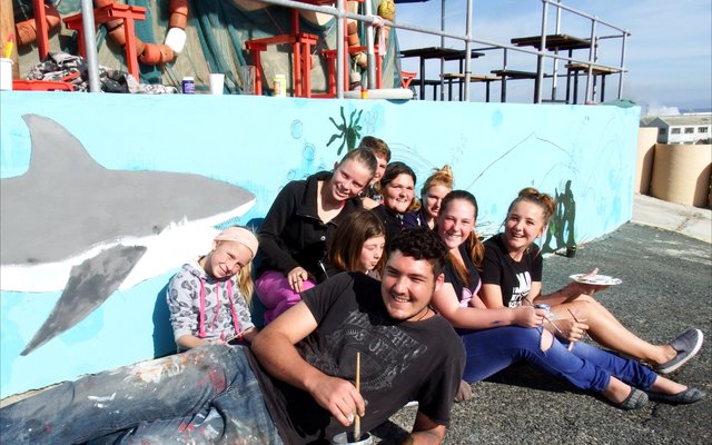 â€˜n Deel van die groep jongelinge wat twee lang mure by De Seemans Taphuis verlede Saterdag met verf betakel het â€“ maar wel op â€˜n kunstige wyse met â€˜n skilderagtige resultaat. Voor lÃª die groep se â€œhoofmanâ€, TJ Nortje.