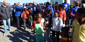 Selfs kinders het opgewonde en al dansende aan Premier Helen Zille se optog in Masakhane se strate deelgeneem. Tweede van links gee Premier Zille en Rdl Dudley Coetzee mekaar â€˜n handdruk.
