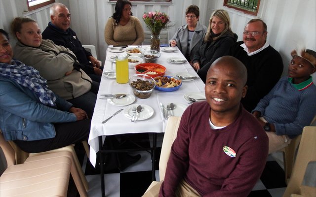 Regs voor sit â€˜n trotse Ally Msweli tydens die amptelike opening van sy eie toerbedryf in Masakhane, Masakhane Township Tours, saam met van die gaste wat die opening bygewoon het.