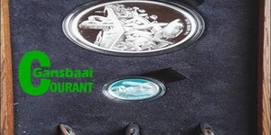 Die gemonteerde R2 en 2Â½c silwermuntstukke, met dolosafdrukke daarop, waarmee Aubrey Kruger enkele weke voor sy afsterwe deur die Suid-Afrikaanse Munt vereer is.  