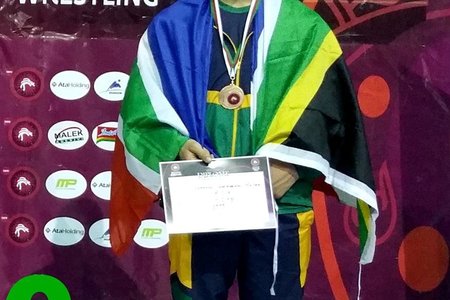 Johan Hulme, kleinseun van Johan en Elcine Hulme van Franskraal, pas nadat hy â€˜n bronsmedalje vir sy derde plek in Grieks/Romeinse stoei in AlgeriÃ« ontvang het.  