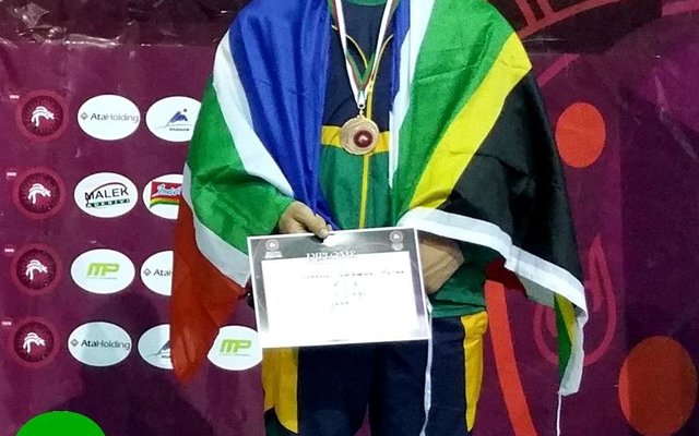 Johan Hulme, kleinseun van Johan en Elcine Hulme van Franskraal, pas nadat hy â€˜n bronsmedalje vir sy derde plek in Grieks/Romeinse stoei in AlgeriÃ« ontvang het.  