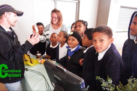 Christoff Longland van Whale Coast Conservation beklemtoon die ekonomiese waarde van Fynbos aan Gansbaai PrimÃªr se leerders,  met Marieta Rademeyer van die skool wat toekyk.  