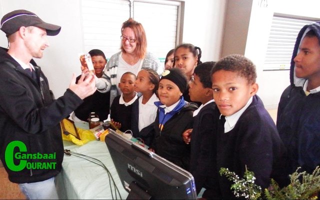Christoff Longland van Whale Coast Conservation beklemtoon die ekonomiese waarde van Fynbos aan Gansbaai PrimÃªr se leerders,  met Marieta Rademeyer van die skool wat toekyk.  