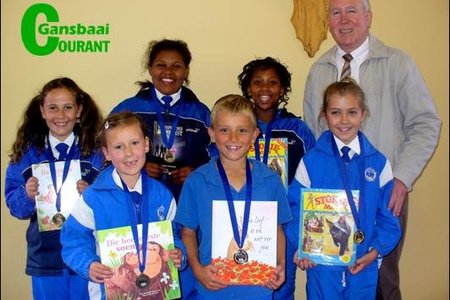 Op die foto oorhandig die skoolhoof, mnr. Eben van der Merwe dit aan die trotse groepie.  Agter van links Carla Oosthuizen (Gr 3), Jay-Andra Pieters (Gr 6), Nevellia October (Gr 5) en mnr. Eben van der Merwe.Â   Voor van links Anke Oosthuizen (Gr 1), Stefan Stieger (Gr 2) en Lara Strydom (Gr 4).