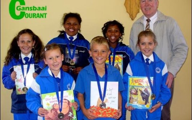 Op die foto oorhandig die skoolhoof, mnr. Eben van der Merwe dit aan die trotse groepie.  Agter van links Carla Oosthuizen (Gr 3), Jay-Andra Pieters (Gr 6), Nevellia October (Gr 5) en mnr. Eben van der Merwe.Â   Voor van links Anke Oosthuizen (Gr 1), Stefan Stieger (Gr 2) en Lara Strydom (Gr 4).