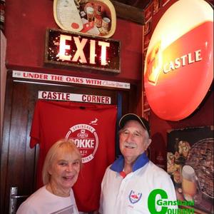David MacDonald, host for the craft beer tasting in his house, with his wife, Margaret in his own â€œCastle Cornerâ€ with the EXIT sign from the Newlands Cricket Legends Grounds, which forms part of his private collection.  