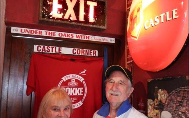 David MacDonald, host for the craft beer tasting in his house, with his wife, Margaret in his own â€œCastle Cornerâ€ with the EXIT sign from the Newlands Cricket Legends Grounds, which forms part of his private collection.  