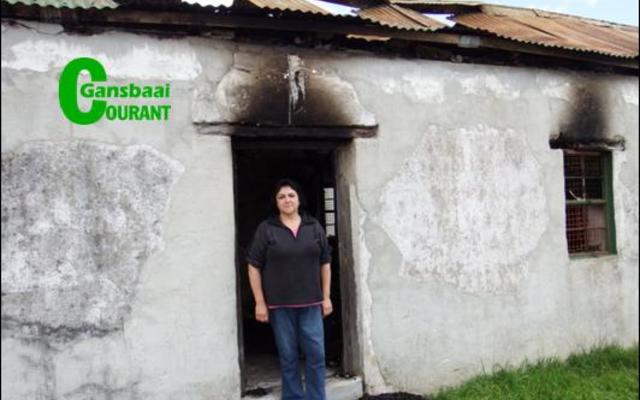 Truida Fourie staan in die deur van die erfenis-woning in Bâ€™Bos, waar sy gebore is, wat deur â€˜n brand vernietig is.
