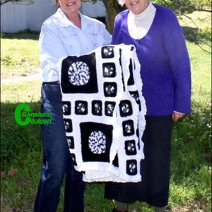 Luise Boeddinghaus, die wenner van â€˜n uitgelote swart en wit kombers, ontvang die kombers van Overstrand se voormalige Uitvoerende  Burgemeester, Raadsdame Nicolette Botha-Guthrie.