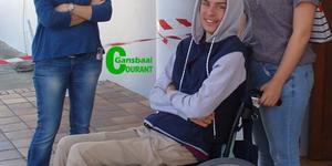 â€˜n Spontane en glimlaggende Calvin Olivier in sy rolstoel tydens â€˜n nootlegging wat ten bate van hom deur Laerskool Gansbaai gereÃ«l is. By hom is sy ma, Denise Olivier (links) en Mikayla Groenewald.