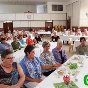 â€˜n Gesellige oomblik by die mooi versierde tafels tydens die jaarafsluiting van die NG Vrouediens, wat deur die Kleinbaaistreek gereÃ«l is.