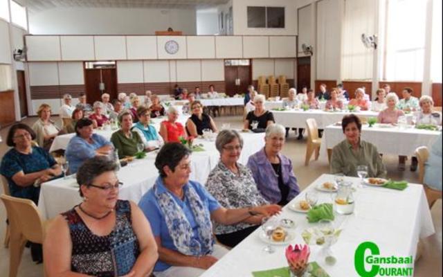 â€˜n Gesellige oomblik by die mooi versierde tafels tydens die jaarafsluiting van die NG Vrouediens, wat deur die Kleinbaaistreek gereÃ«l is.