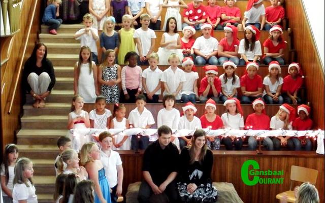 Josef en Maria by die Christuskind, met laerskoolleerders besig met koorsang.
