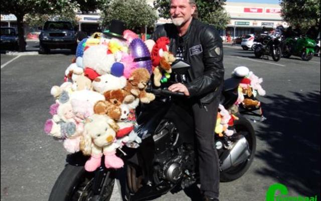 Johan Pretorius van die Family Christian Church (FCC) in die Kaap sit hier op sy Kawasaki 1000 met sy speelgoed. Johan het â€˜n vorige rekord van een en sestig sagte speelgoed wat aan â€˜n motorfiets vasgemaak was, verbeter na sewentig, wat nou die nuwe rekord is.