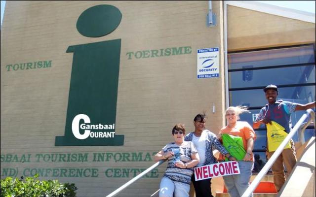 Die span by die Gansbaai Toeriste- en Inligtingsentrum is hier wel windverwaaid, maar staan slaggereed vir besoekers aan ons dorp. Van links Glenda Kitley (bestuurder), Maureen Valentine, Doulene Els en Akhona Jordaan.  Die sentrum is langs die Great White Junction (Superspar) winkelsentrum geleÃ«.