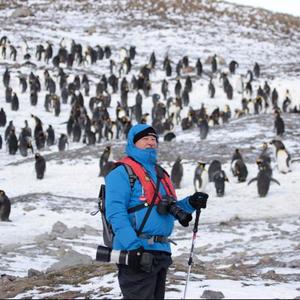 Wilfred Chivell, the â€œice-manâ€ during his and Susan Visagieâ€™s visit to the Salisbury Plain in South Georgia, with thousands of King penguins behind him.