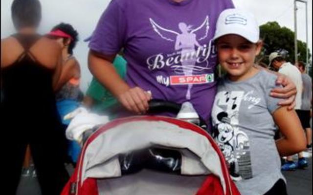 Baba AJ Palvie (6 maande) lyk net so opgewonde oor die 5km pretstap as  sy  ma  Chanel  (agter) en Danique Barnard (8) langs die stootwaentjie.