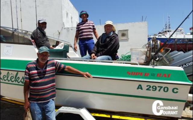 Skipper Jean Downing staan voor sy boot, RelÃªks II, met sy bemanning vlnr op die boot Bertus Prins, George Rowan en Philip Fourie nÃ¡ hulle hengeldag op see.