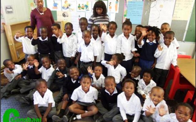 Masakhane Primary School se 52 graad Râ€™e het ook aanvanklik aan hul kospakkies vasgeklou met die neem van die foto. Agter links is Ellen Pato (Gr R.a) en regs is Xoliswa Hoza (Gr R.b).