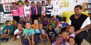 Gansbaai PrimÃªr in Blompark se 60 graad Râ€™e het met moeite afstand gedoen van hul kospakkies met die neem van die foto. Regs sit Karen Benjamin (Gr R.2). Helena Slammat (Gr R.1) was afwesig met die neem van die foto.