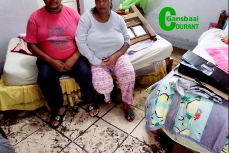 Hulle splinternuwe bed en matras is deur die watermassa wat deur hul huis gevloei het, verskuif.  Die verslae egpaar, Petrus en Sylvia van Wyk van Blompark, sit hier in hulle slaapkamer.