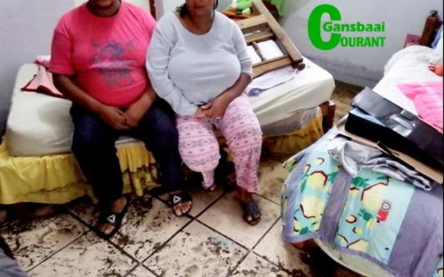 Hulle splinternuwe bed en matras is deur die watermassa wat deur hul huis gevloei het, verskuif.  Die verslae egpaar, Petrus en Sylvia van Wyk van Blompark, sit hier in hulle slaapkamer.