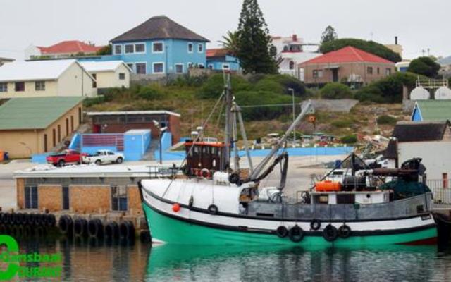 Die foto vertoon â€˜n deel van die area in Gansbaai hawe waar â€˜n man van Walvisbaai verdrink het. In die agtergrond kan die geskiedkundige â€œBlou Huisâ€ bokant die hawe gesien word wat gedurende die naweek onder â€˜n inbraak deurgeloop het.