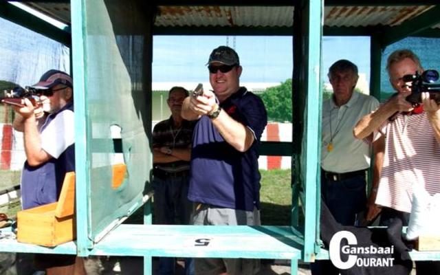 Gelukkig vir die fotograaf was Alec Kitley, baanbeampte van Gansbaai Pistoolskietklub, se bevel â€œOntlaai! Verklaar!â€ met die neem van hierdie foto. Vlnr Johan van der Mescht, Berno Punt en Andrew Mac Queen wat met hul ontlaaide wapens verby die fotograaf mik. Agter vlnr hou Alec Kitley en Andy Hammond (veiligheidsoffisier) die situasie fyn dop. 