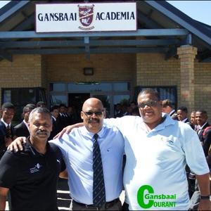 Peter de Villiers, voormalige Springbokafrigter (links) saam met Tommy Wilson (skoolhoof) en Samuel Theron (CEO: Sport Implementation Foundation) staan hier voor Gansbaai Academia waar die o/16 en o/19 rugbyspanne hom met â€˜n erewag verwelkom het.