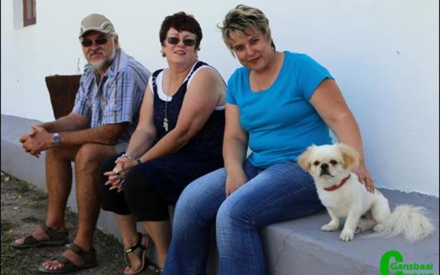 Mense het van heinde en ver gekom vir die jaarlikse basaar.  Hier kuier Denita en Johan Gousard, nuwe intrekkers in Gansbaai vanaf Hendrina, saam met Liesle Volschenk en haar hondjie, Lappies van Napier. Die vrolike groepie het gesÃª hulle sit aan die â€˜airconâ€™-kant van die saal.