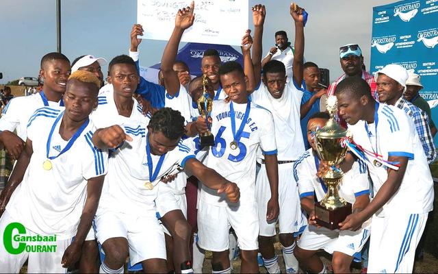 Stanford Young Tigers FC pump their fists in the air in exultation and hold the winning trophy and cheque aloft with great pride after being crowned the undisputed winners in Saturdayâ€™s soccer grand finale.