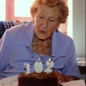 Ouma Mick blaas die '102' kerse dood.