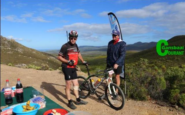 Heinrich Smith van Franskraal luier â€˜n bietjie by die waterpunt om die pragtige uitsig en verversings te geniet, terwyl Du Toit KotzÃ© sy fiets vashou.