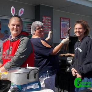 Gansbaai Academia het â€˜n worsbroodjieverkoping  voor OK Foods Gansbaai gehou gedurende die    Paasnaweek as deel van hulle blikskuddag.  Die vrolike werkers is drie Vermeulens uit dieselfde huishouding â€“ van links Jessica, hulle ma Esther en Anita.