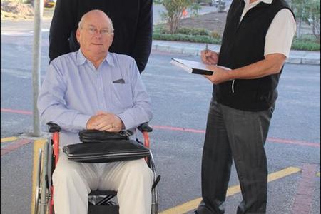 Deputy Mayor Dudley Coetzee has taken up the Wheelchair Wednesday challenge to walk in the shoes (so to speak!) of a wheelchair user. With him are (right) Don Kearney, area manager of the Hermanus Administration and Gerhard Smit, manager of social development.