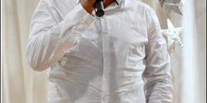 Abduragmaan Adams, of te wel Ian October van die sepie, Suidooster en eregas tydens Gansbaai Academia se Cultivaria-aand, spreek die leerders en gaste toe.  