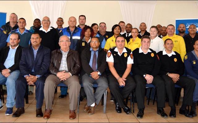 The Overstrand Fire Department recently hosted an end of fire season debriefing session at the Pringle Bay Community Hall. Front fltr Overstrandâ€™s Cllr Fanie Krige (Kleinmond), Cllr Grant Cohen (Kleinmond), Neville Michaels (Director:  Protection Services), Coenie Groenewald (Municipal Manager), Cllr Arnie Africa (Portfolio Head:  Protection Services), Lester Smith (Chief:  Fire, Rescue and Disaster Management), Marlu Rust (Snr Disaster Management Officer) and Angelo Aplon (Ass Chief:  Fire, Rescue and Disaster Management). The large group at the back included officials of the Overstrand Traffic, Fire and Law Enforcement, Overberg District Municipality, Greater Overberg Fire Protection Association, City of Cape Town Fire and Rescue, CapeNature, NCC Environmental Services and Provincial Traffic.