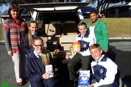 Die â€œbakkie volâ€ nie-bederfbare kruideniersware is deur alle leerders van Laerskool Gansbaai en hul ouers geskenk. Dit het ten doel om Badisa se noodkamer aan te vul. Voor van links is Mia van Eeden (onderhoofdogter) en Christoff Dahl (onderhoofseun). Agter van links is Alanda Brown (Badisa administrasie), Monique Hugo (hoofdogter), Gavin Middleton (hoofseun) en Madelein Fourie (Badisa Maatskaplike Hulpwerker).