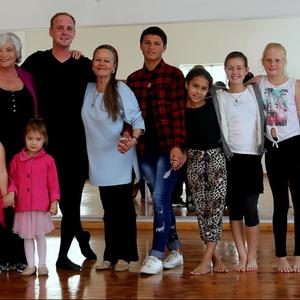 Christopher staan hier saam met Cynthie Aggenbag (links van hom) en Lynette van Wyk (regs van hom) omring deur â€˜n groep opgewonde kinders. 