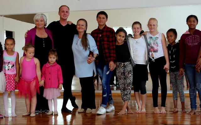 Christopher staan hier saam met Cynthie Aggenbag (links van hom) en Lynette van Wyk (regs van hom) omring deur â€˜n groep opgewonde kinders. 