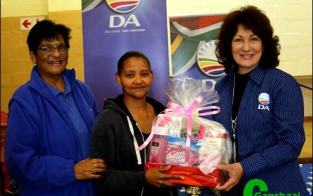 Daar was talle gelukstrekkings, maar die grootste geskenkpak is vir heel laaste gelaat.  Die wenner daarvan was Miriam Valentine wat  hier saam met die DA-gasvroue Moira Opperman en Riana de Coning glimlag.