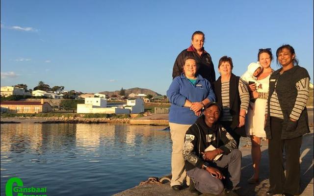 Die ontspanne groep selfoonfotograwe na afloop van hulle insiggewende werkswinkel oor selfoonfotografie tegnieke. Voor sit Akhone Jordaan. Middel van links Doulene Els, Glenda Kitley, Maraika van Wessen met haar klein Violet in haar arms en Maureen Valentine. Agter staan Jean-Marie van Eck. (Foto deur Leanne Dryburgh, aanbieder.)