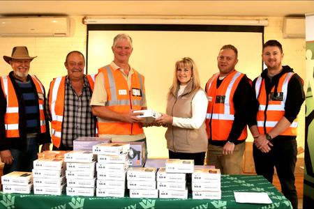 Gansbaai was die eerste dorp in Suid-Afrika wat tegnologies gevorderde digitale radios ontvang het om misdaadbekamping te vergemaklik.  Hier oorhandig Elmarie van Dalen, voorsitter van AfriForum se Overstrand-tak die radios amptelik aan Mark Collings, voorsitter van die Groter Gansbaai Buurtwag.  In hulle splinternuwe glimbaadjies staan die buurtverteenwoordigers van links:  Johan Pieterse (Perlemoenbaai), Kobus van Staden (Franskraal), Cassie Smith (Kleinbaai), Mark (De Kelders) en Elmarie, Hugh-Daniel Grobler (Gansbaai â€“ ook ondervoorsitter van die Groter Gansbaai buurtwag) en Johan du Toit (Pearly Beach). 